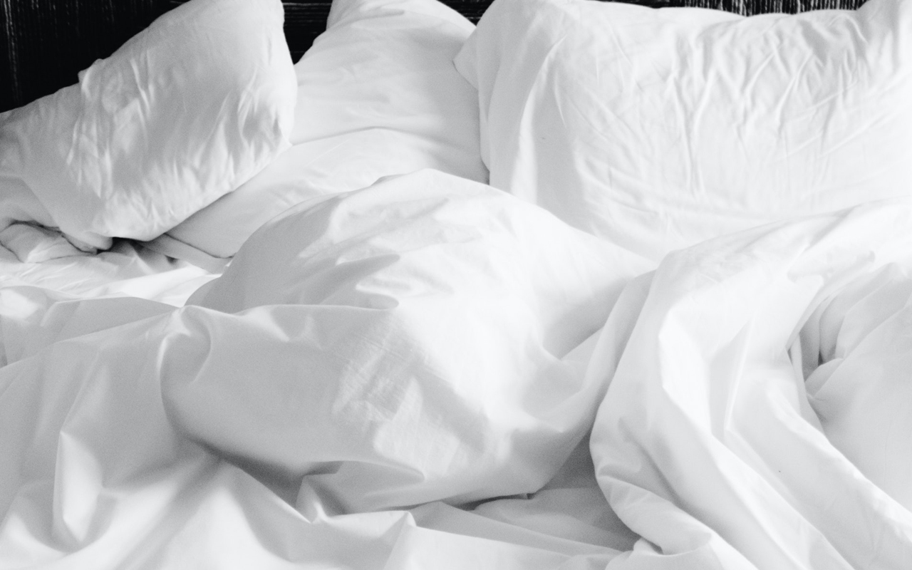 Untidy bed linens on a bed